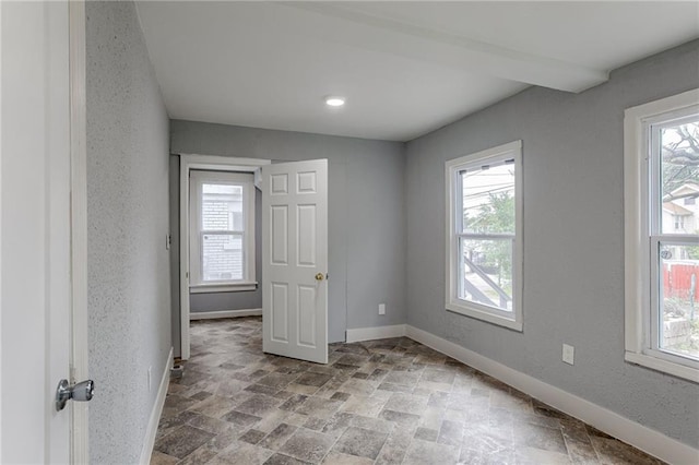 unfurnished room featuring a wealth of natural light and tile floors