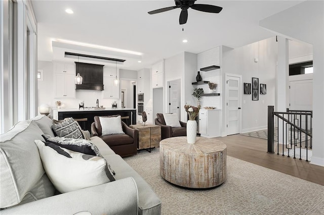 living room with ceiling fan and light wood-type flooring