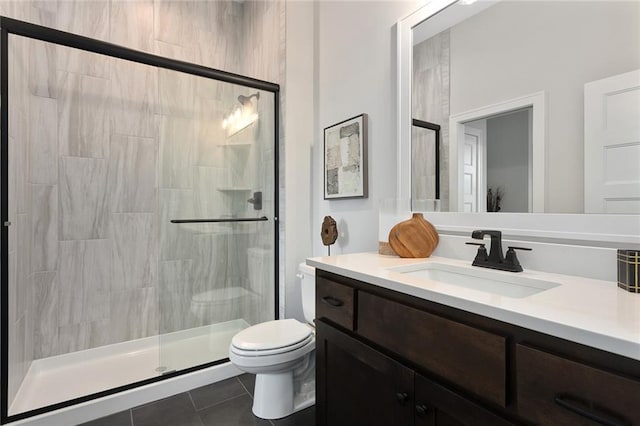 bathroom with tile patterned floors, vanity, an enclosed shower, and toilet