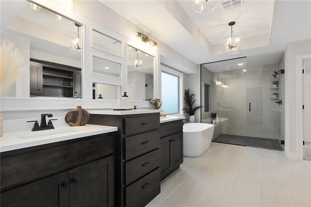 bathroom with vanity, a raised ceiling, and shower with separate bathtub