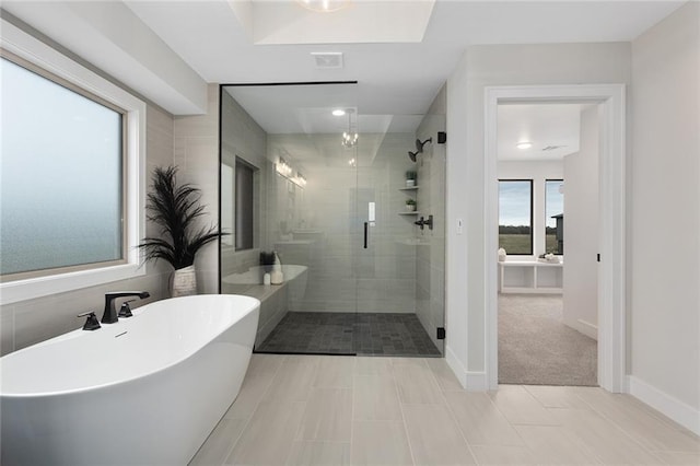 bathroom featuring tile patterned floors and separate shower and tub