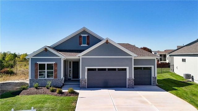 craftsman inspired home featuring a front yard and a garage