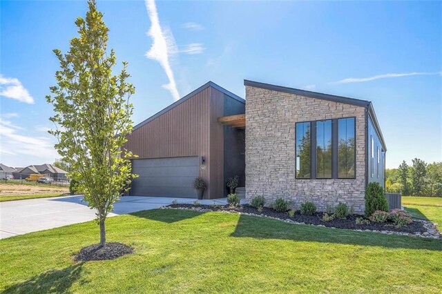 modern home featuring a garage, a front lawn, and central AC