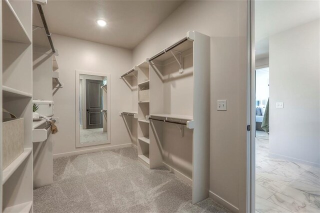 walk in closet featuring light colored carpet