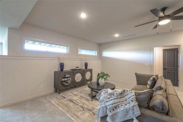 carpeted living room with ceiling fan