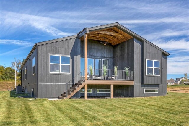 rear view of property featuring a lawn and central air condition unit