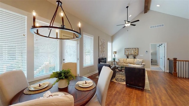 interior space with ceiling fan with notable chandelier, hardwood / wood-style floors, high vaulted ceiling, and beam ceiling