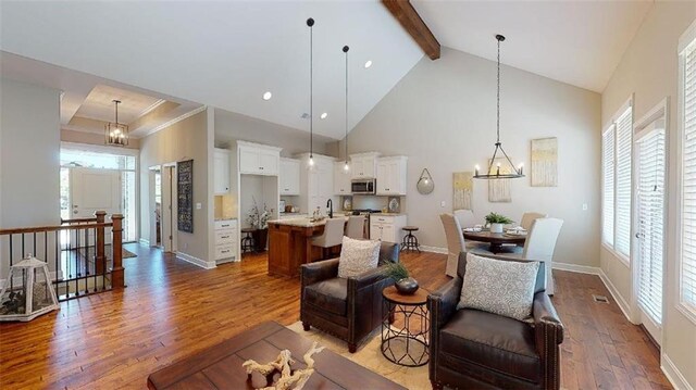 living room with a wealth of natural light, dark hardwood / wood-style flooring, and a chandelier