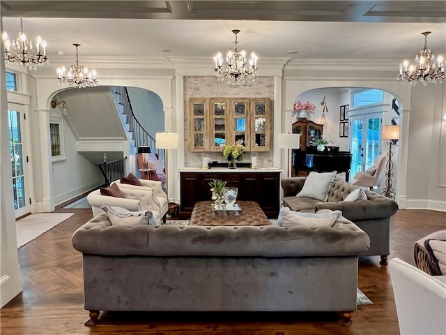 living room featuring parquet flooring, ornamental molding, and an inviting chandelier