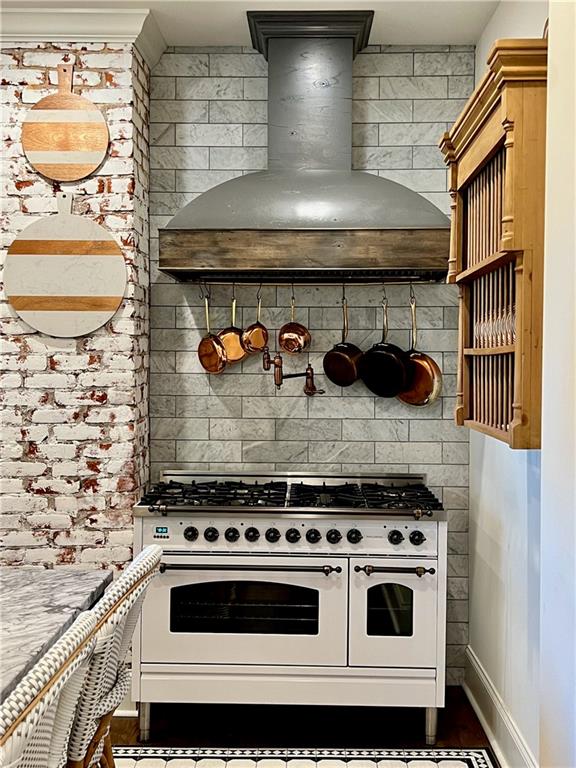 kitchen featuring range with two ovens and custom exhaust hood