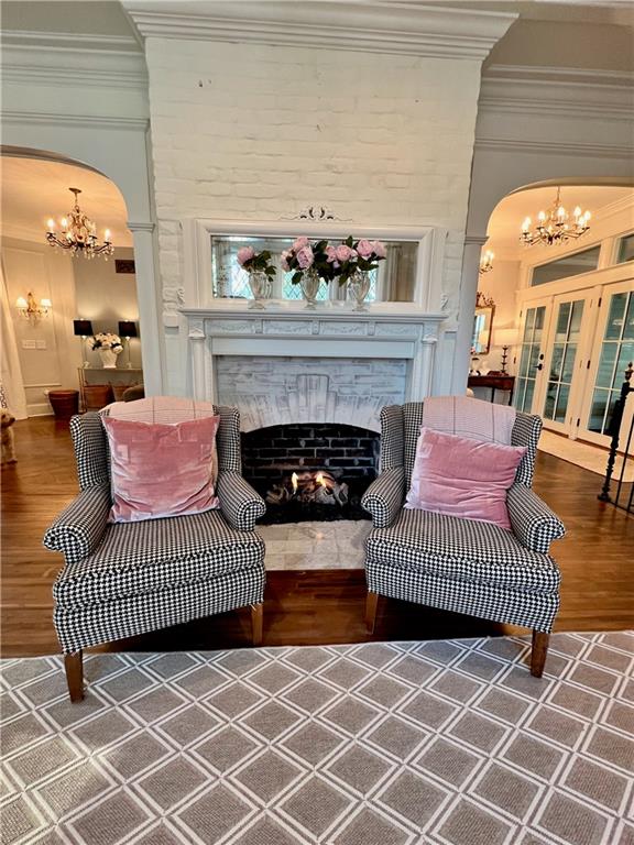 living room featuring dark wood-type flooring, an inviting chandelier, and ornamental molding