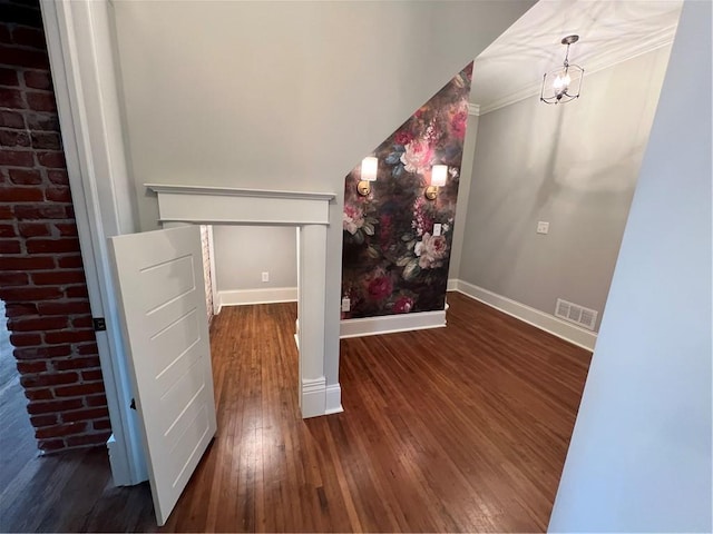 foyer featuring ornamental molding, brick wall, and dark hardwood / wood-style floors