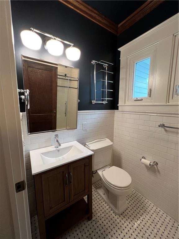 bathroom with tile walls, vanity, toilet, and tile flooring