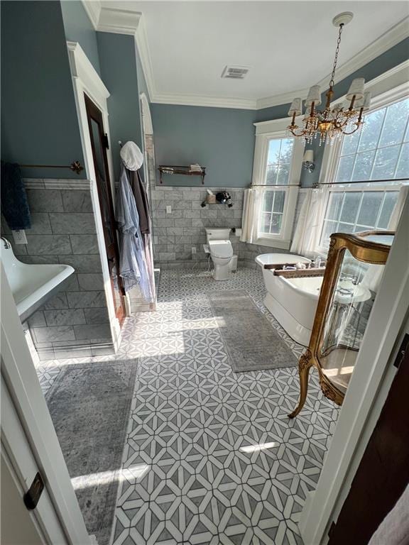 bathroom with tile flooring, a notable chandelier, tile walls, and crown molding