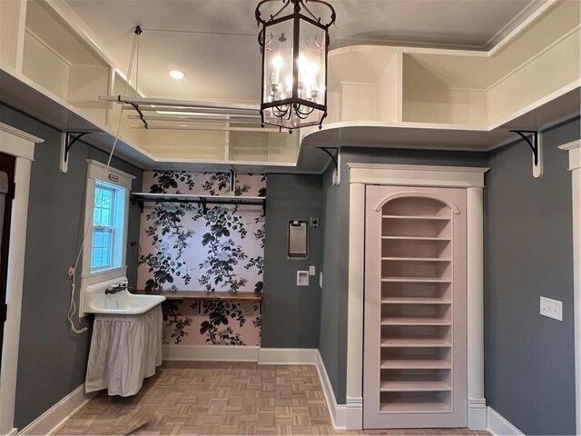 bathroom featuring sink, an inviting chandelier, and parquet floors