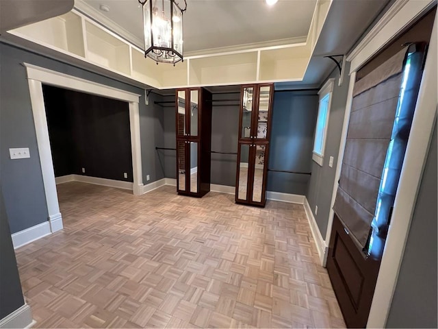 walk in closet with parquet flooring and a notable chandelier