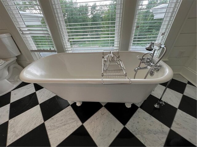 bathroom featuring tile flooring and a bath