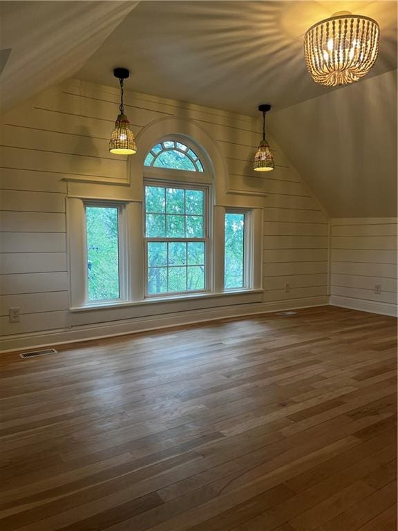 interior space with a healthy amount of sunlight, vaulted ceiling, and dark wood-type flooring