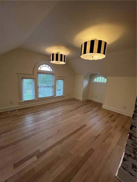 additional living space featuring hardwood / wood-style flooring and vaulted ceiling