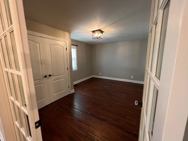 unfurnished room with dark wood-type flooring