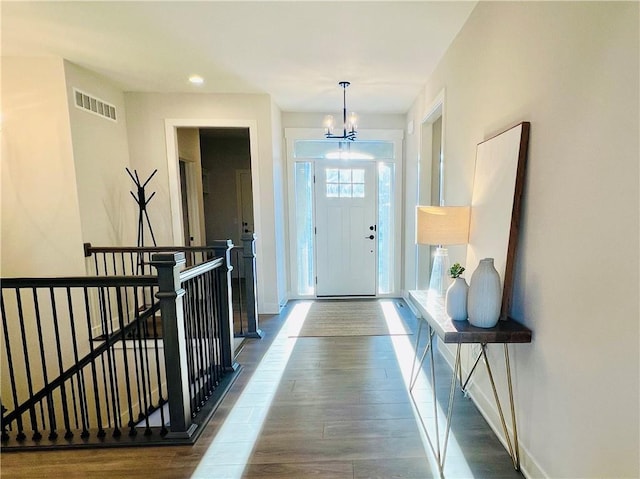 entryway with a chandelier and dark wood-type flooring