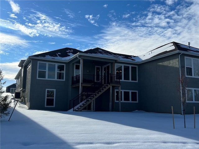 view of snow covered back of property