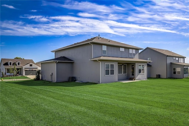 back of property with central AC and a lawn