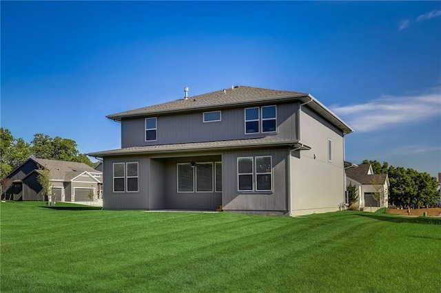 back of property with a garage and a lawn