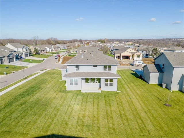 back of property featuring stucco siding, a residential view, and a yard