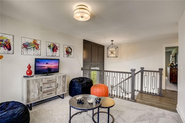 sitting room with carpet flooring and an upstairs landing