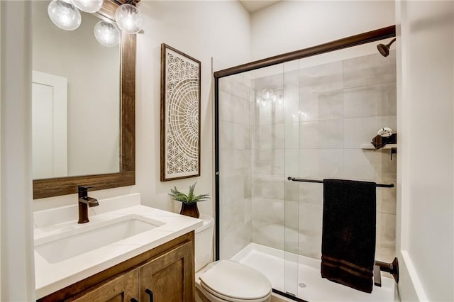 bathroom featuring a shower stall, toilet, and vanity