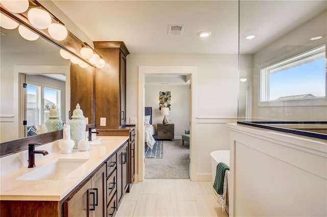 ensuite bathroom featuring double vanity, visible vents, a sink, and ensuite bathroom