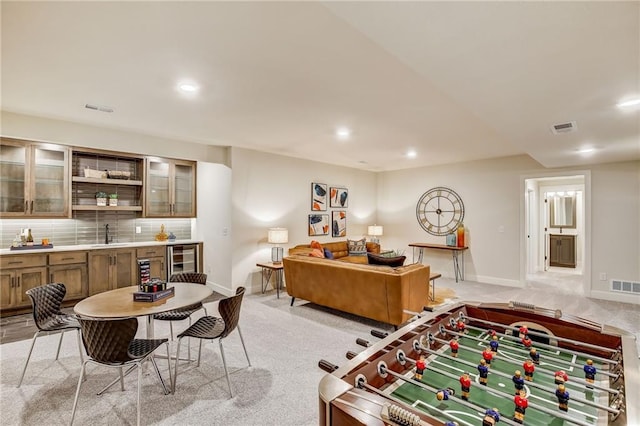 playroom featuring beverage cooler, visible vents, a sink, and light carpet