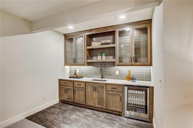 bar featuring baseboards, decorative backsplash, wine cooler, a sink, and recessed lighting