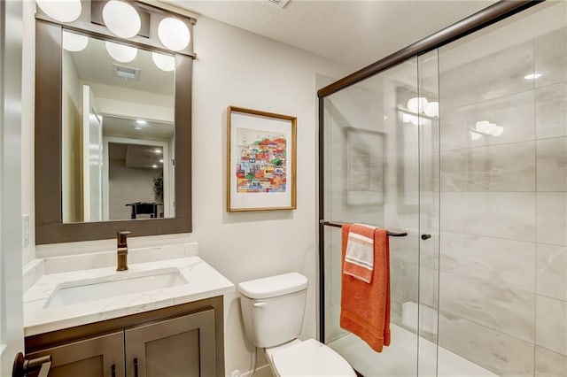 full bathroom featuring toilet, a stall shower, visible vents, and vanity