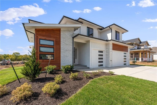 contemporary house featuring a garage and a front lawn