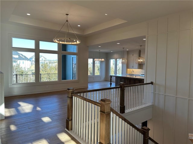 interior space featuring wood finished floors, a raised ceiling, and recessed lighting