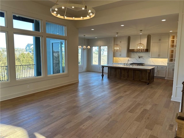 kitchen with wood finished floors, light countertops, a sink, and an inviting chandelier