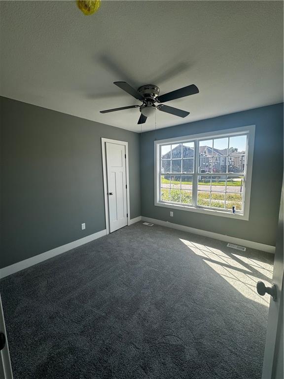 empty room with carpet flooring and ceiling fan