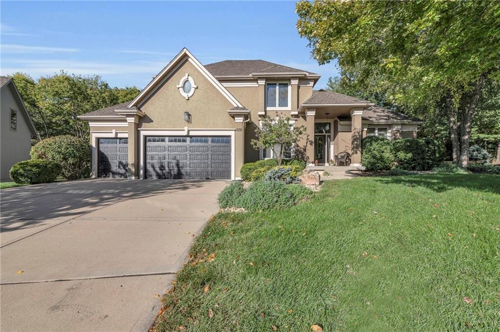 view of property with a garage and a front lawn