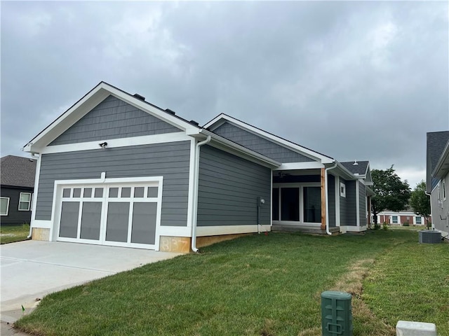 view of side of home featuring a garage, central AC, and a lawn