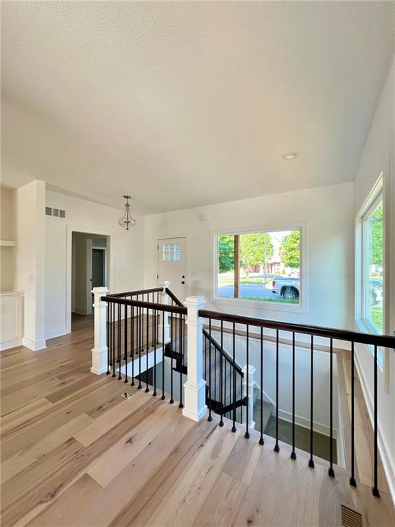 stairs featuring hardwood / wood-style floors and a textured ceiling