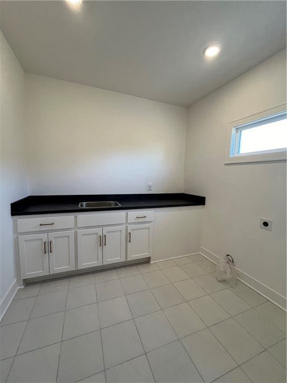 washroom featuring cabinets, sink, hookup for an electric dryer, and light tile patterned flooring