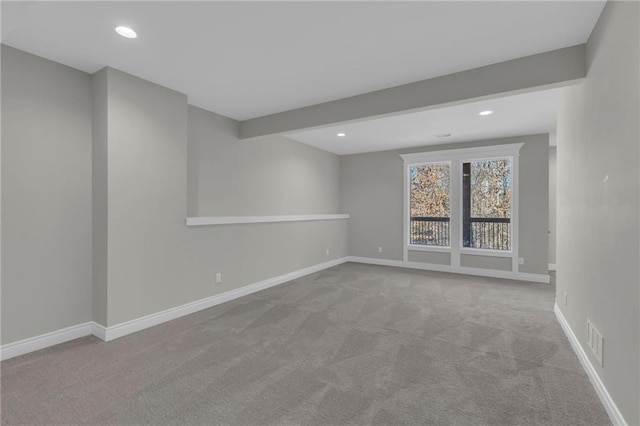 carpeted empty room with beam ceiling