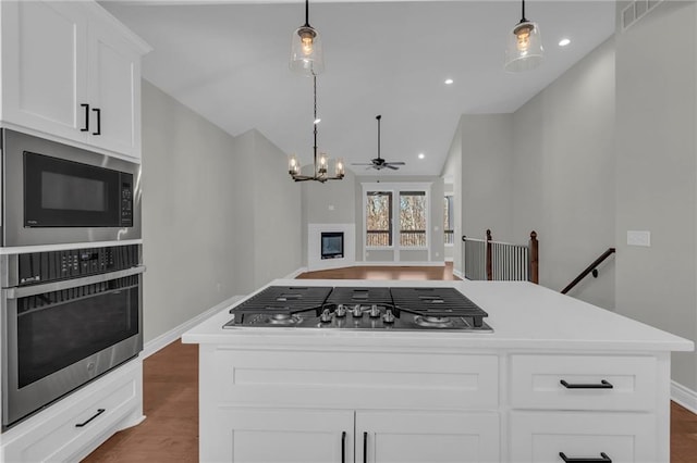 kitchen with hanging light fixtures, stainless steel appliances, and a center island