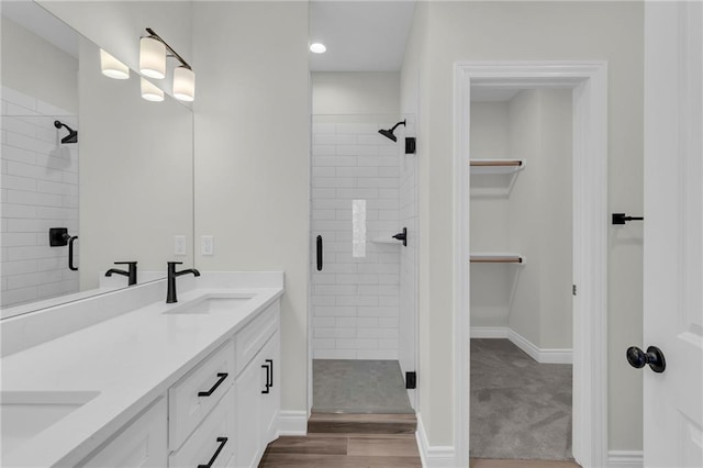 bathroom featuring a shower with shower door, hardwood / wood-style floors, and vanity