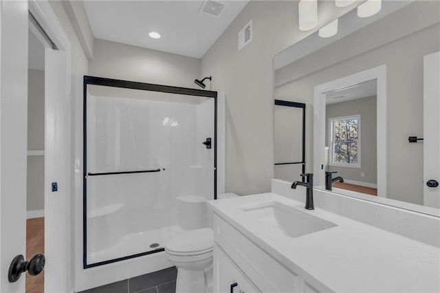 bathroom featuring toilet, tile patterned floors, an enclosed shower, and vanity