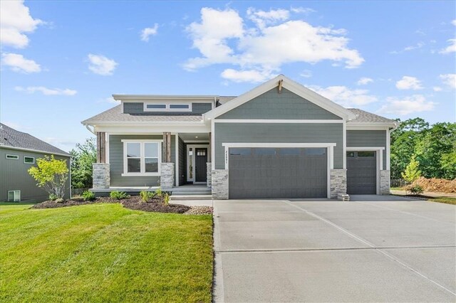 craftsman house with a front lawn and a garage