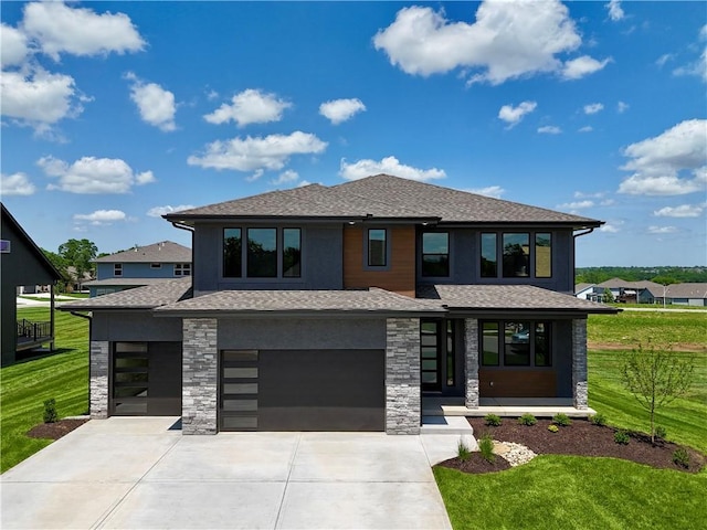 prairie-style home with a front yard and a garage