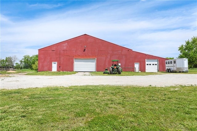 view of shed / structure with a garage and a lawn